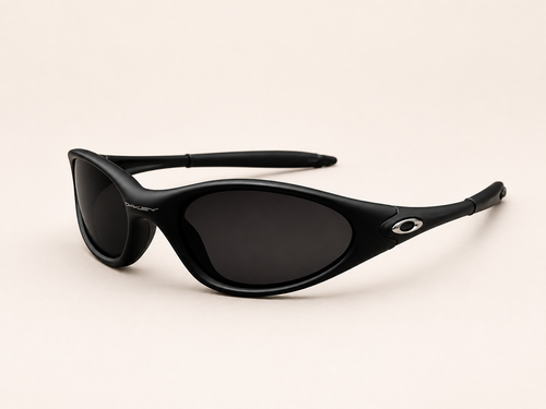 Three-quarter view of black Oakley Minute sunglasses with dark lenses, curved frame and silver oval temple accents.