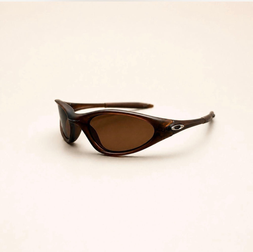Oakley Minute brown sunglasses with brown lenses and silver oval temple details, three-quarter view.