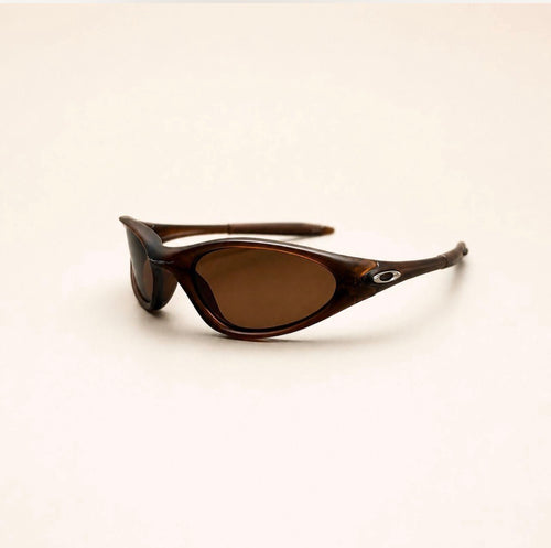 Oakley Minute brown sunglasses with brown lenses and silver oval temple details, three-quarter view.